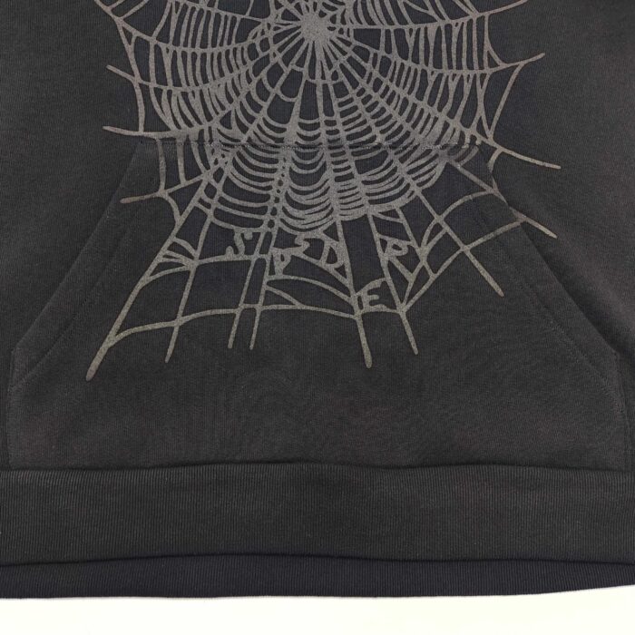 Felpa nera con design di ragnatela dettagliata e tasca anteriore, stile goth e alternativo.