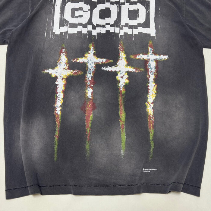 T-shirt nero streetwear con croci colorate e parola GOD effetto glitch e stile distressed.
