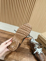 Dettaglio della suola di scarpa sportiva con manicure rossa e sfondo in legno elegante.