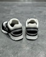 Scarpe sportive nere e bianche, retro, altezza tallone imbottito, design moderno e stabile.