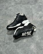 Scarpe sportive nere e bianche moderne con suola antiscivolo e design resistente.