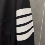 Manica nera sportiva con tre strisce bianche, stile moderno e casual.