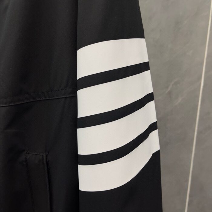 Manica nera sportiva con tre strisce bianche, stile moderno e casual.