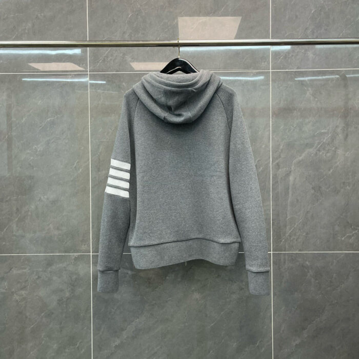 Felpa grigia sportiva con cappuccio e dettagli a strisce bianche, ideale per casual e sport.