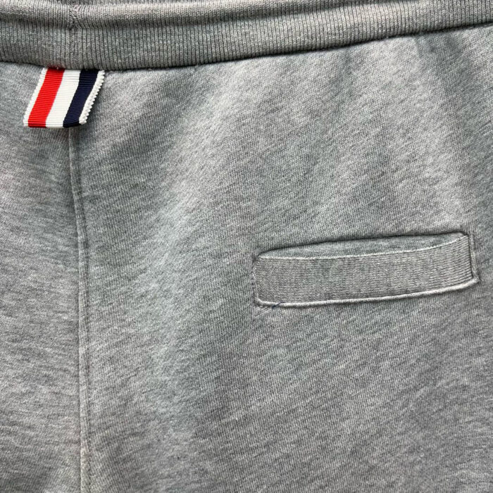 Pantaloni jogger grigi con dettaglio colorato sulla vita e tasca posteriore discreta.