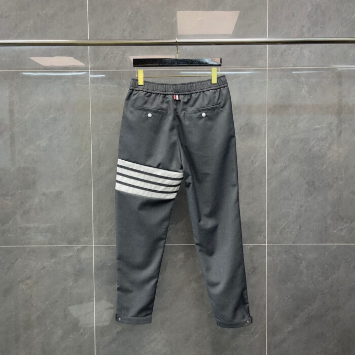 Pantaloni sportivi grigi con strisce bianche, comodi, elasticizzati, stile moda streetwear.