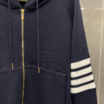 Felpa navy con strisce bianche, zip oro e texture waffle, casual e sportiva.