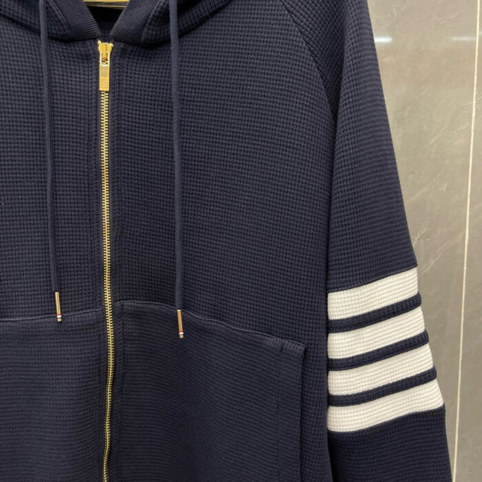 Felpa navy con strisce bianche, zip oro e texture waffle, casual e sportiva.