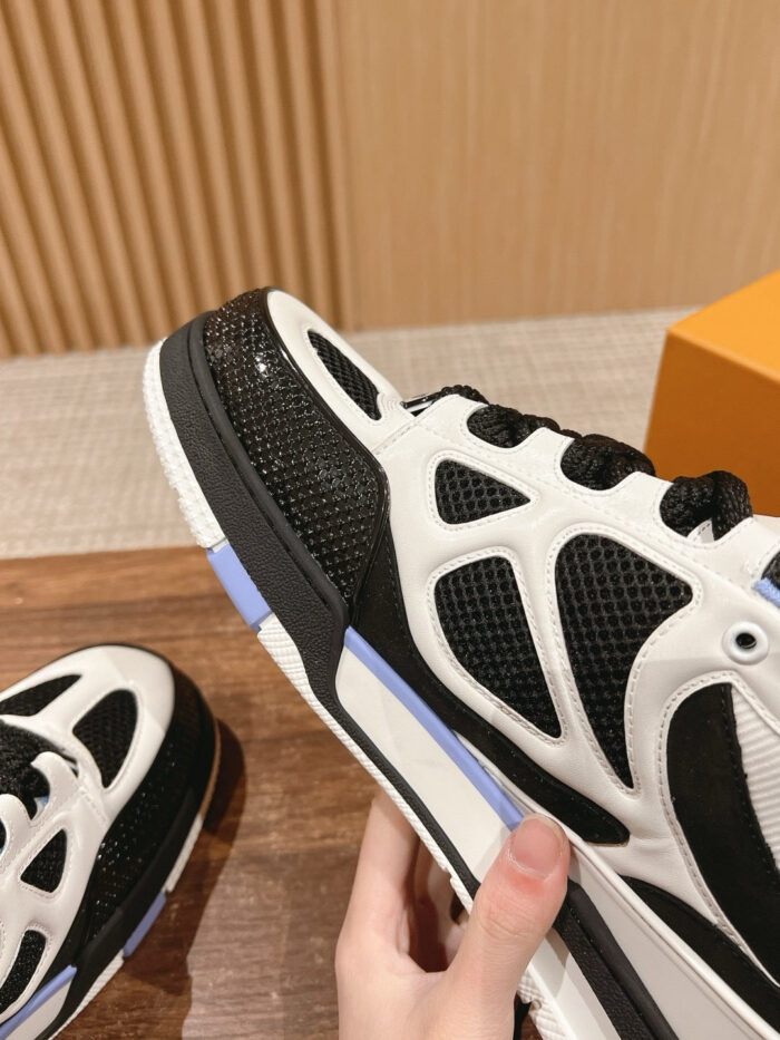 Sneaker sportiva bianca e nera con dettagli blu, comfort, stile casual e tecnologia antiscivolo.