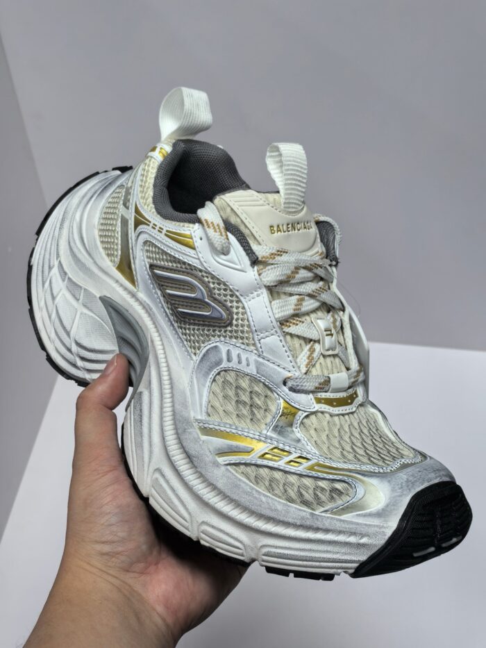 Scarpa sportiva bianca con dettagli riflettenti, suola antiscivolo e design moderno.
