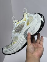 Sneaker sportiva bianca con dettagli gialli, suola nera, design moderno e leggerezza garantita.