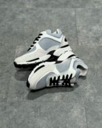 Scarpe da ginnastica bianche sportive, moderne e comode con dettagli in grigio e nero.