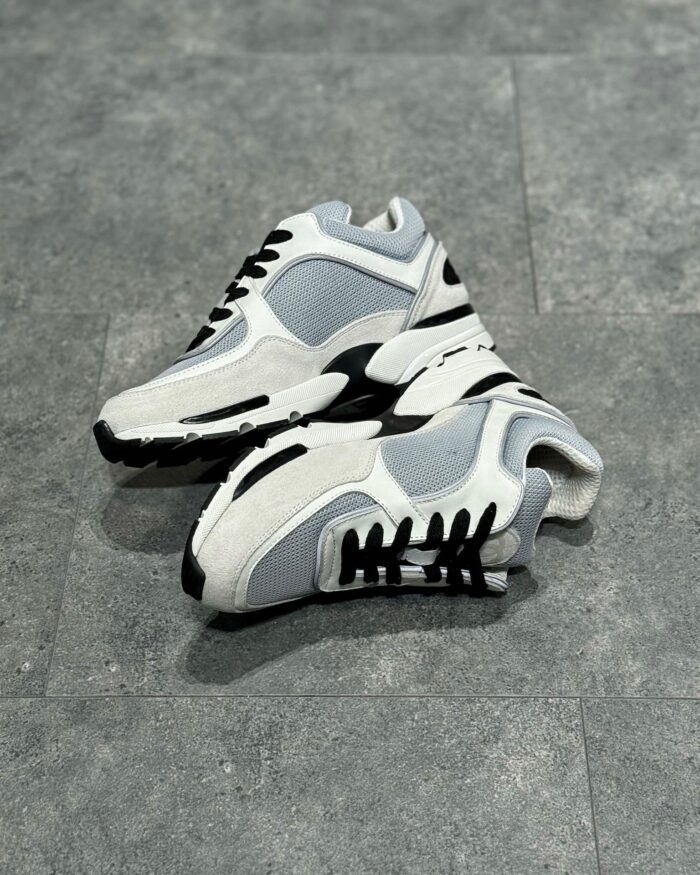 Scarpe da ginnastica bianche sportive, moderne e comode con dettagli in grigio e nero.