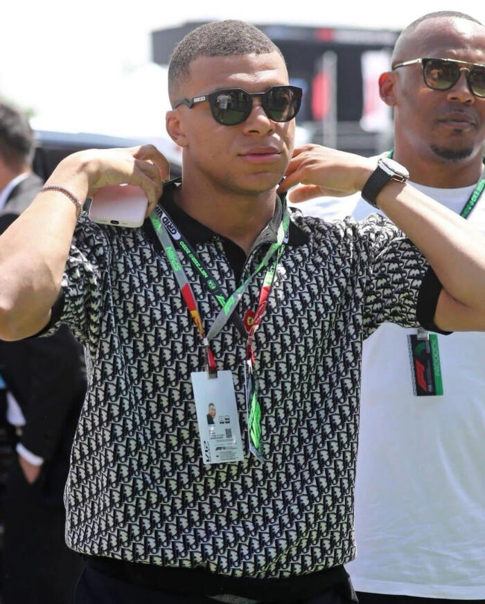 Giovane uomo elegante con occhiali e lanyard a evento sportivo allaperto