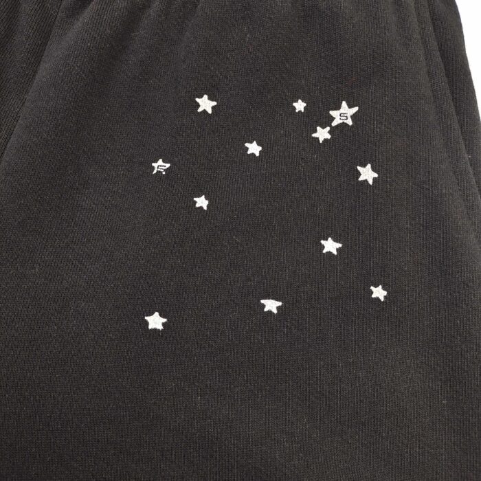 Pantaloni neri con motivo stellato, lettera S e design ispirato al cielo notturno.