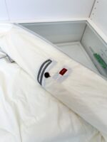Borsa porta vestiti bianca in ambiente moderno e minimalista, ideale per organizzare abbigliamento.