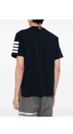 Maglietta nera con strisce bianche e shorts grigi, stile streetwear casual e moderno.