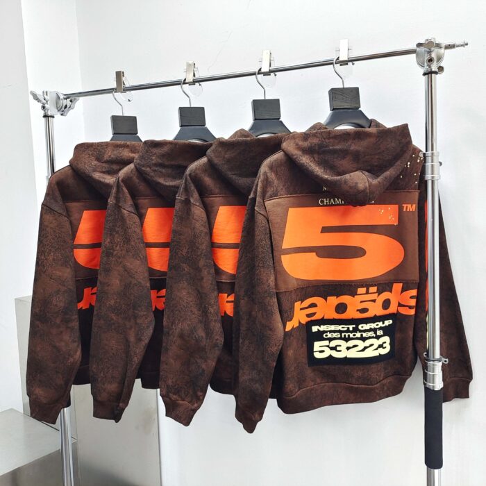 Felpe streetwear marroni con grafica numerica arancione e dettagli trendy in boutique elegante