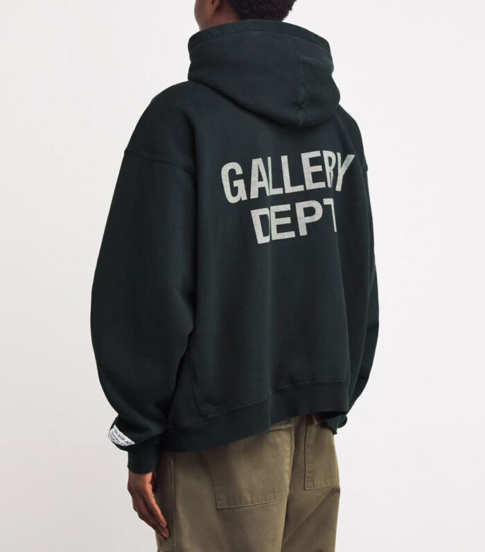 Felpa oversized verde scuro GALLERY DEPT con scritta bianca, abbinata a pantaloni khaki casual.