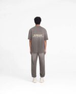 Look casual streetwear con T-shirt REPRESENT e sneakers bianche su sfondo minimalista