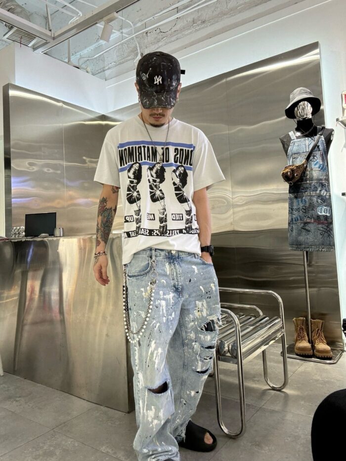Giovane in streetwear trendy in ambiente urbano moderno con mannequin e design contemporaneo.