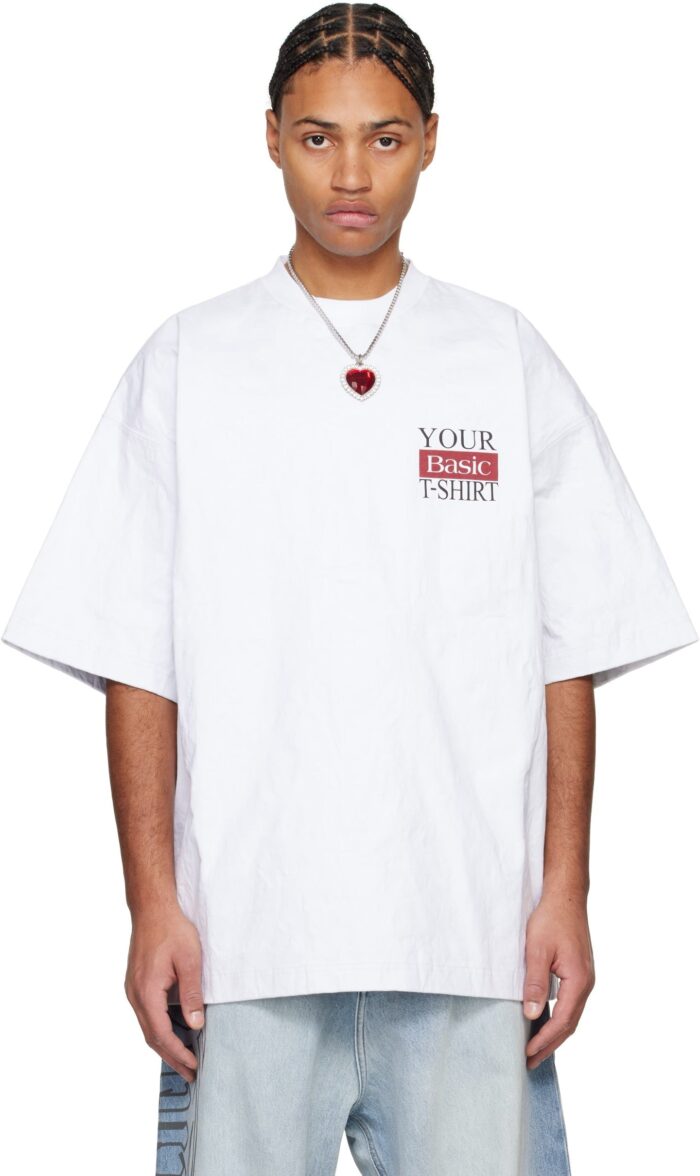 Giovane in streetwear con T-shirt oversize, jeans distressed e collana a cuore, stile giovane e urbano.