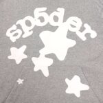 Felpa grigia con lettering sp5der e stelline cartoon, stile casual e giovane.