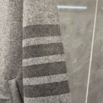 Manica in maglia grigia con strisce doppie eleganti, stile casual e moderno.