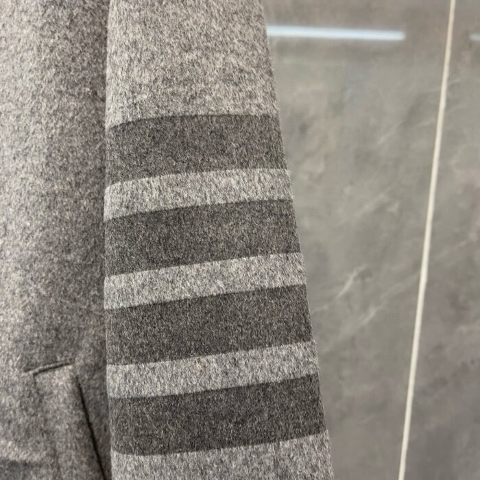 Manica in maglia grigia con strisce doppie eleganti, stile casual e moderno.