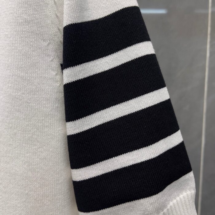 Maglione casual con manica a righe bianche e nere, stile moderno e confortevole.