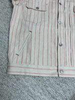 Camicia a righe con tasche frontali e laterale, stile casual e moderno.