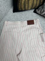 Pantaloni a righe rosa e bianco con patch in pelle e tasche posteriori eleganti.