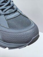 Sneaker grigia sportiva con dettagli in mesh, suola antiscivolo e logo minimalista elegante.