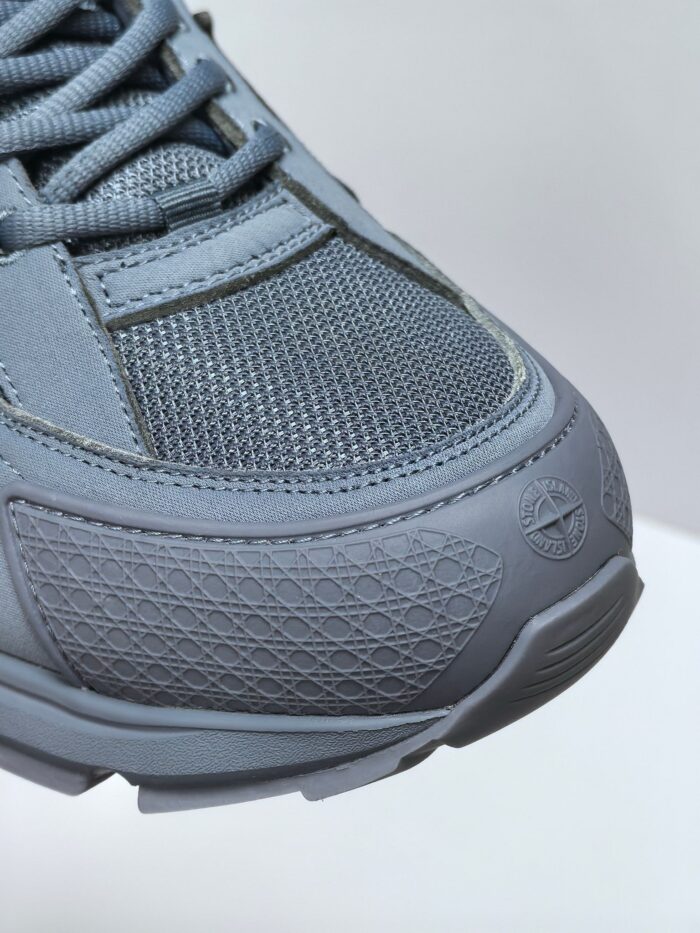 Sneaker grigia sportiva con dettagli in mesh, suola antiscivolo e logo minimalista elegante.