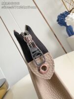 Borsa elegante beige e nera con dettagli in metallo e zip decorativa.