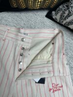 Pantaloni beige Dior con bottoni metallici, righe sottili e stile elegante e confortevole.