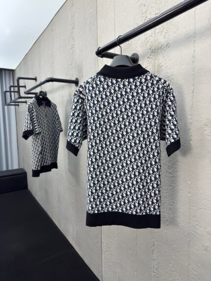 Polo nero e bianco con motivo geometrico, stile elegante e moderno, in esposizione minimalista.