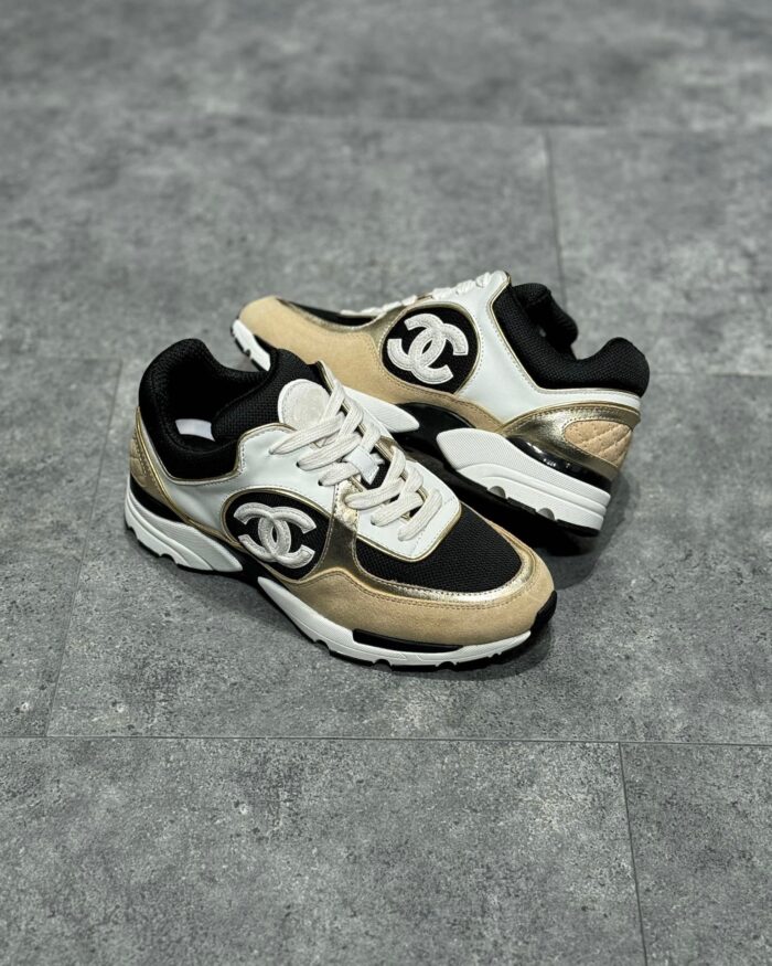 Sneakers nere e beige con logo iconico, suola chunky e design moderno e confortevole.