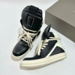 Sneakers alte nere con lacci crema, design moderno e dettagli di stile urbano.