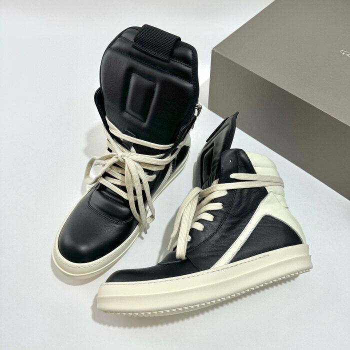 Sneakers alte nere con lacci crema, design moderno e dettagli di stile urbano.