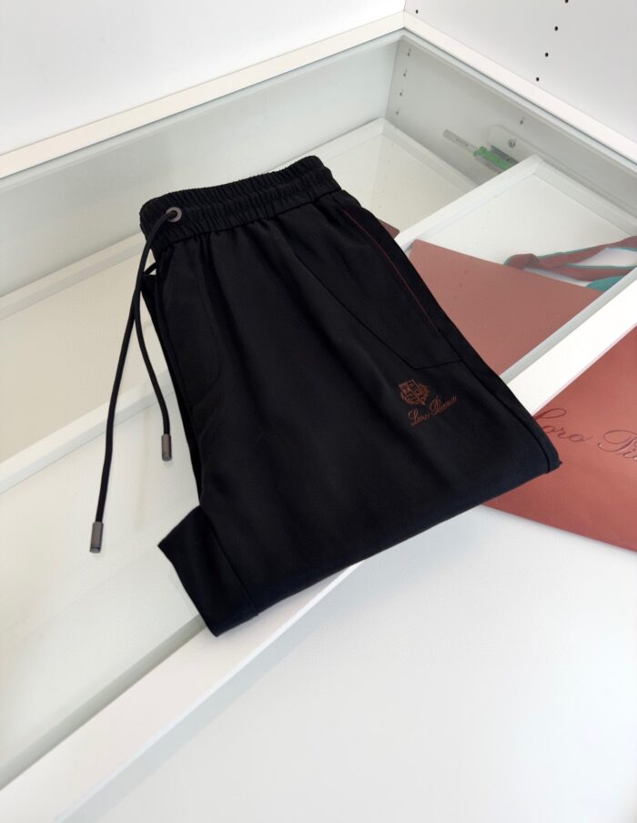 Pantaloni neri casual relax con coulisse, tessuto leggero, logo ricamato, stile versatile e moderno.