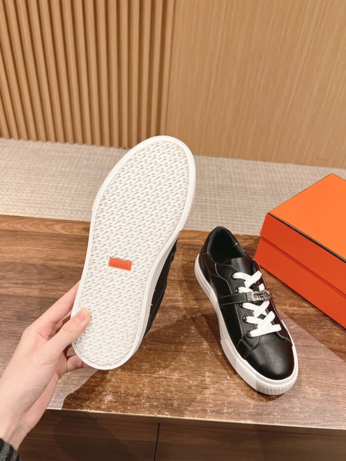 Sneakers nere moderne con suola bianca, stile casual e design trendy, su superficie di legno.