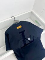 T-shirt nera elegante con logo embossato e dettaglio giallo sul collo.