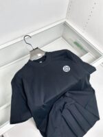 Maglietta nera minimalista con logo discreto, vestibilità comoda, stile semplice ed elegante.