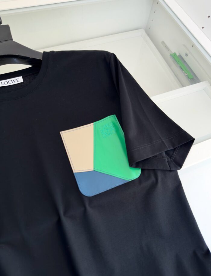 T-shirt nera con tasca geometrica colorata, stile moderno e design artistico.