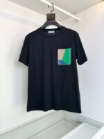 T-Shirt nera casual con tasca colorata in beige, verde e blu, stile moderno e versatile.