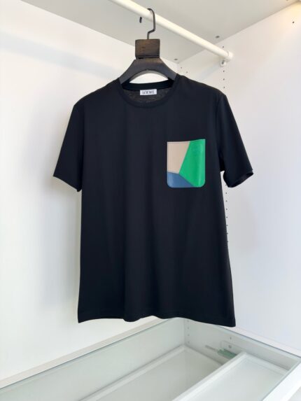 T-Shirt nera casual con tasca colorata in beige, verde e blu, stile moderno e versatile.