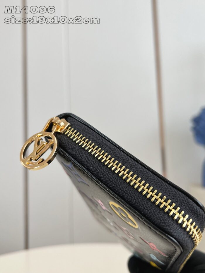 Portafoglio nero elegante con chiusura a zip oro, charm raffinato e design compatto e sofisticato.