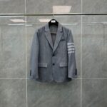 Blazer grigio elegante con dettagli moderni e strisce sulla manica, ideale per ogni occasione.