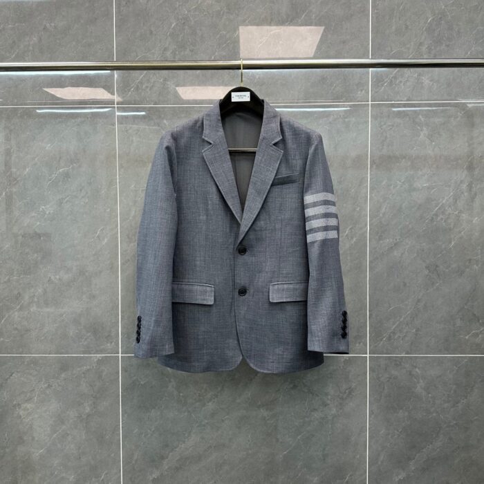 Blazer grigio elegante con dettagli moderni e strisce sulla manica, ideale per ogni occasione.